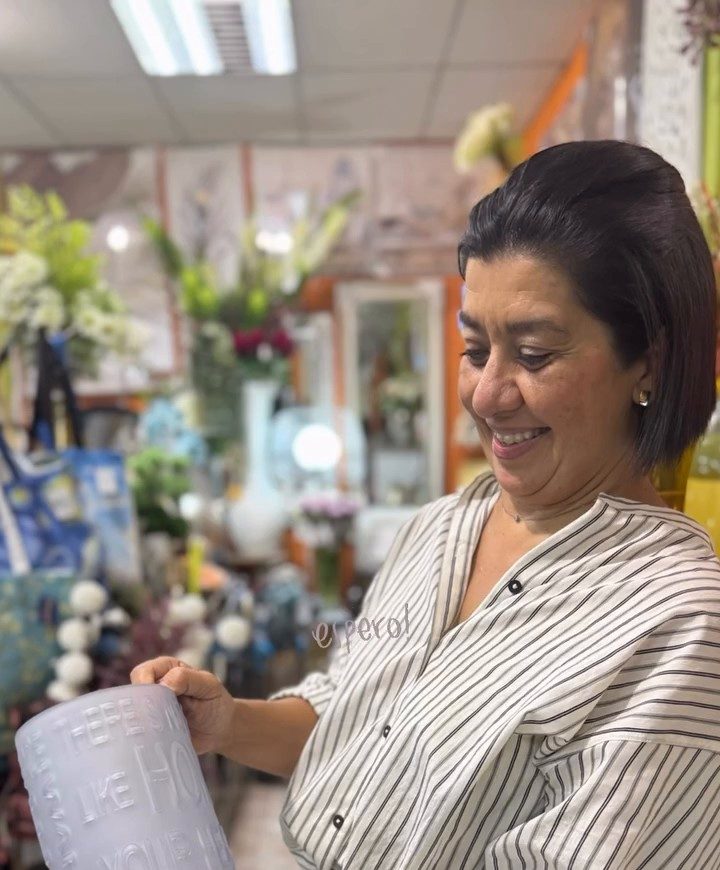 Fátima sonriendo con una maceta en las manos